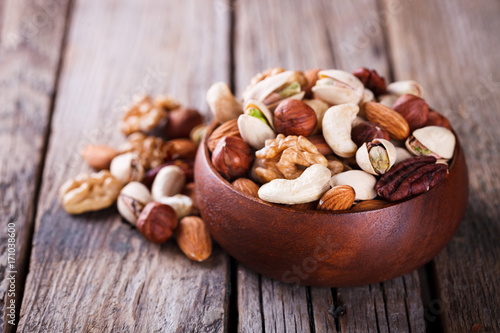 Nuts Mixed in a wooden plate.Assortment, Walnuts,Pecan,Almonds,Hazelnuts,Cashews,Pistachios.Concept of Healthy Eating.Vegetarian.selective focus.