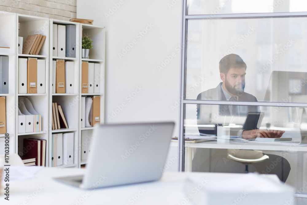 Background image of modern office space with desks and blurred businessman working behind glass wall, copy space Background image of modern office space with desks and blurred businessman working behind glass wall, copy space