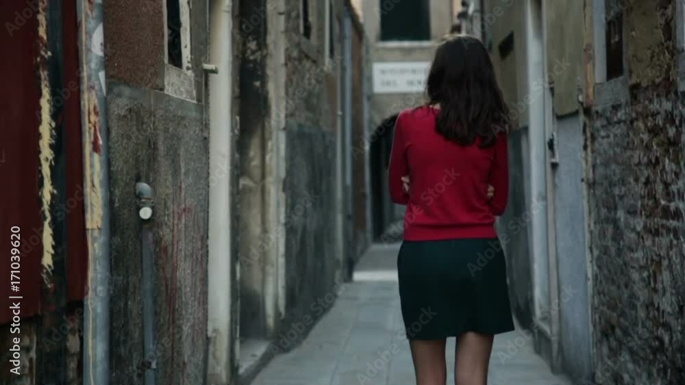 Young girl walks through the narrow streets of Venice Young girl walks through the narrow streets of Venice