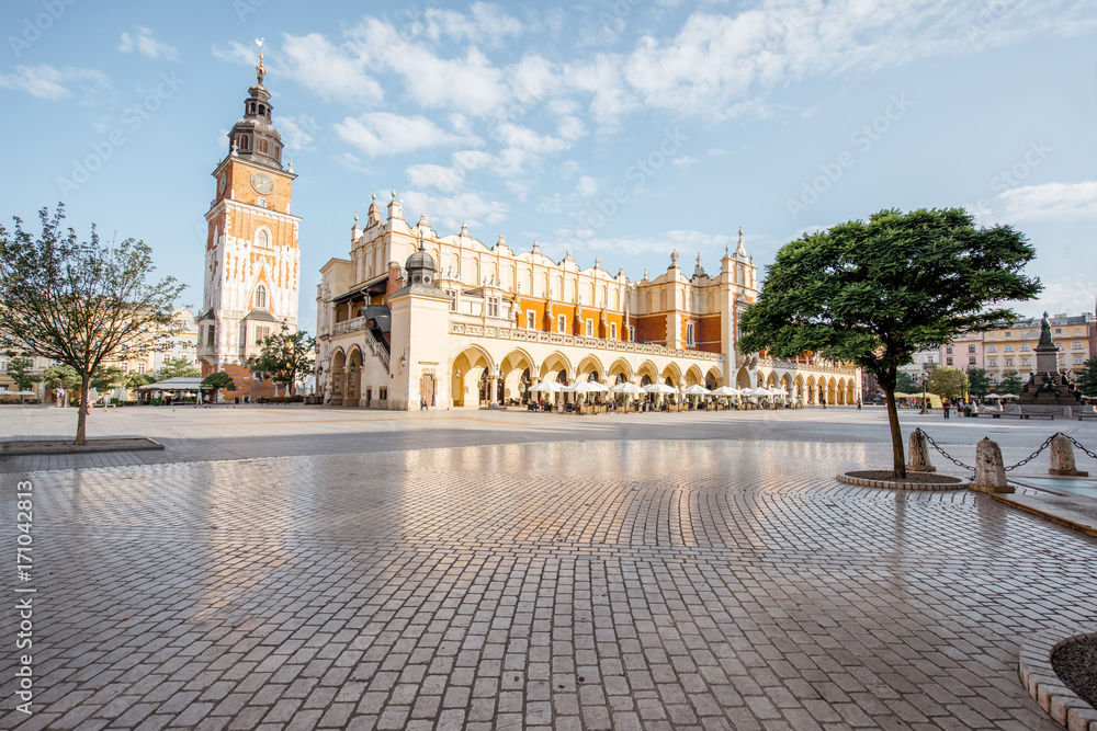 Fototapeta premium Cityscape view on the Market square with Cloth Hall building and town hall tower during the morning light in Krakow, Poland