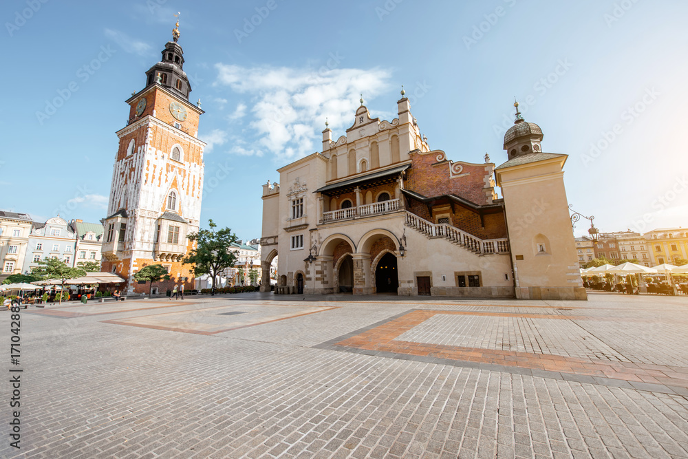 Fototapeta premium Cityscape view on the Market square with Cloth Hall building and town hall tower during the morning light in Krakow, Poland