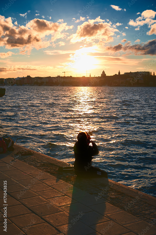Fototapeta premium fisherman on a pier in the city