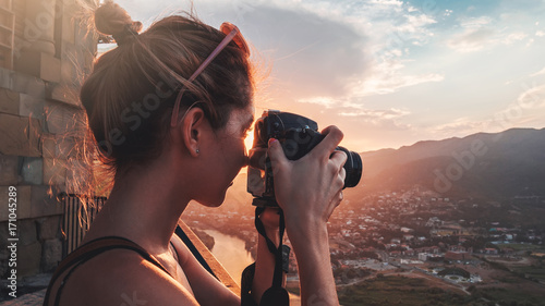 Female photographer, taking pictures of mountain landscape at sunset photo