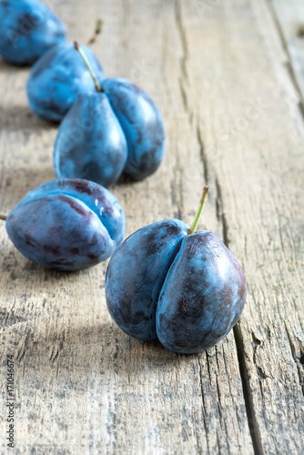 Sweet plums on wooden background Vertical toned