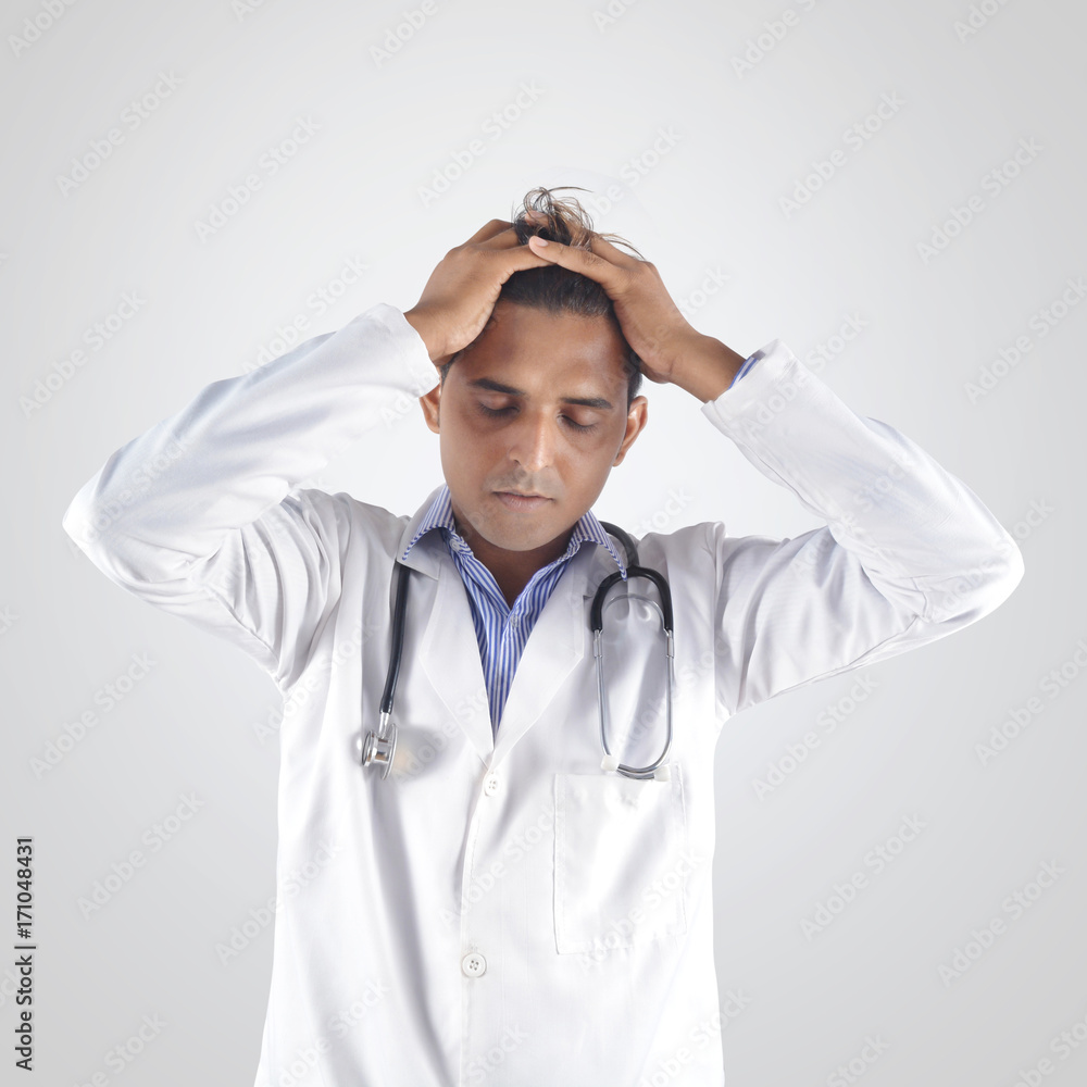 Doctor with stethoscope holding head with hands in tension Doctor with stethoscope holding head with hands in tension