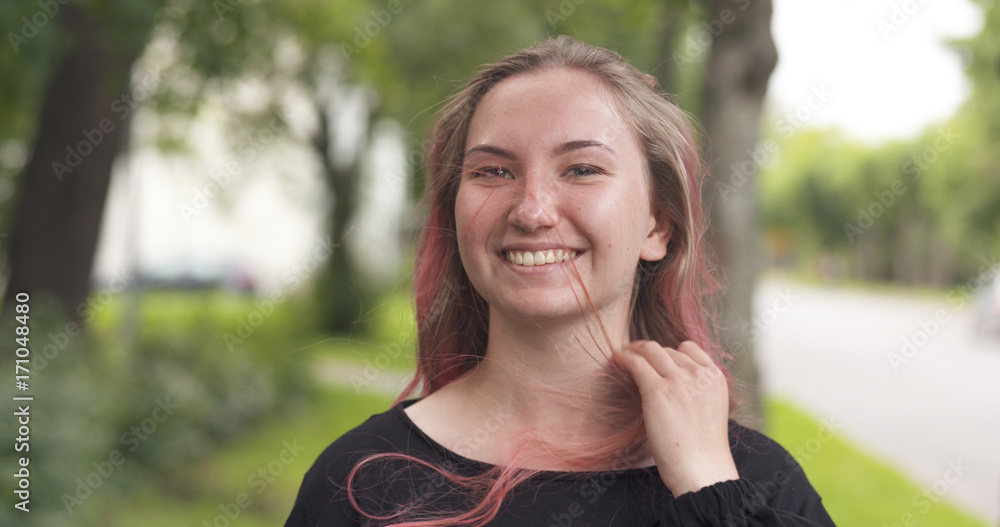 happy smiling teen girl with purple hair standing in town