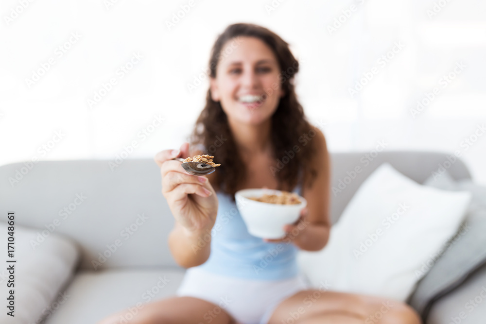 Beautiful young woman eating cereals at home. Beautiful young woman eating cereals at home.