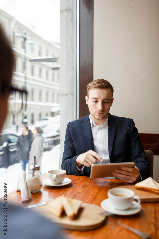 Modern salesman with tablet analyzing online financial information Modern salesman with tablet analyzing online financial information