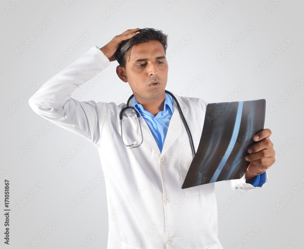 Shocked doctor with stethoscope examining x-ray Shocked doctor with stethoscope examining x-ray