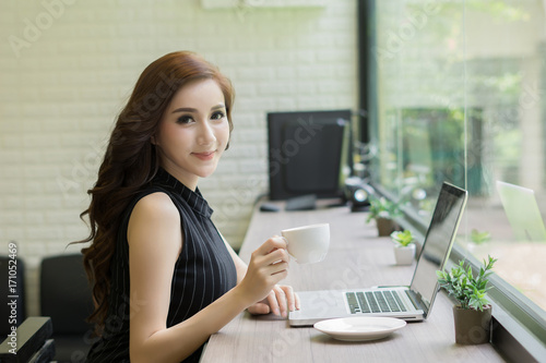 Young business woman working on laptop at office.