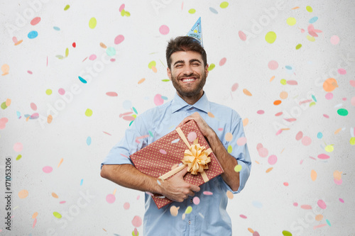 Photography Portrait of cheerful joyful young Caucasian man with beard enjoying his birthday