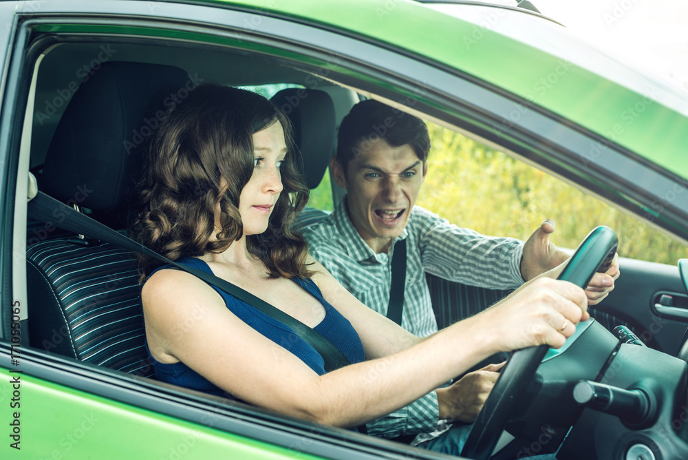 Instructor and female student driving in the car. Concept of the difficulties of training in a driving school Instructor and female student driving in the car. Concept of the difficulties of training in a driving school