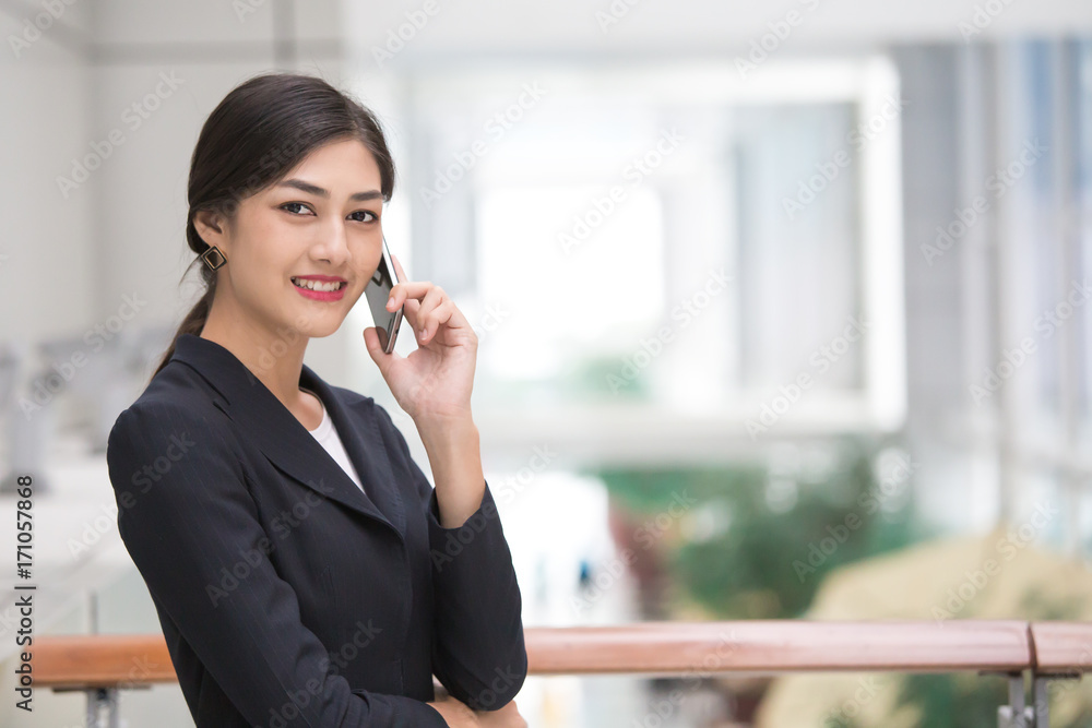 Asian Woman using Smartphone in City with Attractive Smile, Woman working by Smartphone, Woman working Concept. Asian Woman using Smartphone in City with Attractive Smile, Woman working by Smartphone, Woman working Concept.