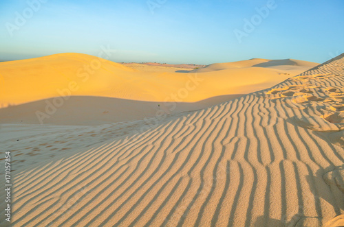Beautiful sand dunes ripples in sunrise morning at White Sand dunes in Muine, Vietnam. Vacation concept background.