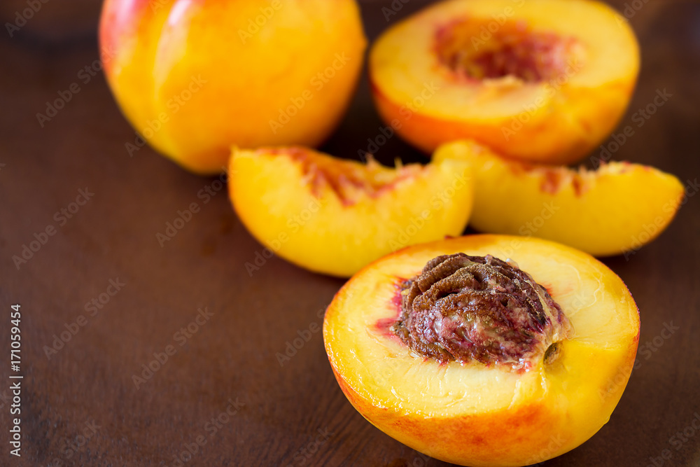 Ripe juicy Nectarines organic fruits whole and slice on wooden background. Selective focus. Toned photo. Ripe juicy Nectarines organic fruits whole and slice on wooden background. Selective focus. Toned photo.