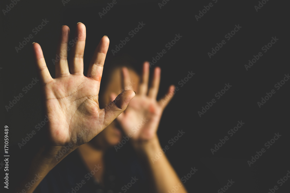 Woman with her hand extended signaling to stop (only her hand is in focus)