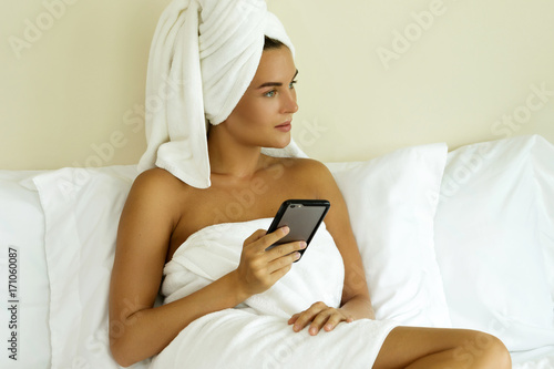 Woman using smartphone in bedroom
