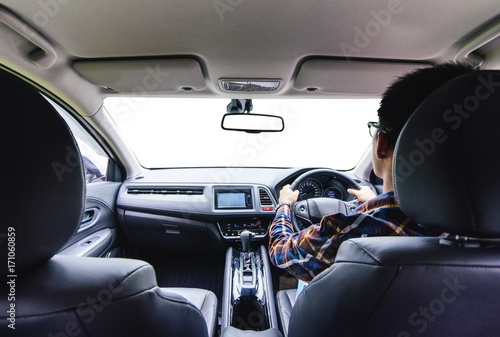 Asian man on hipster shirt hand driving a car with isolated windshield front for driving concept
