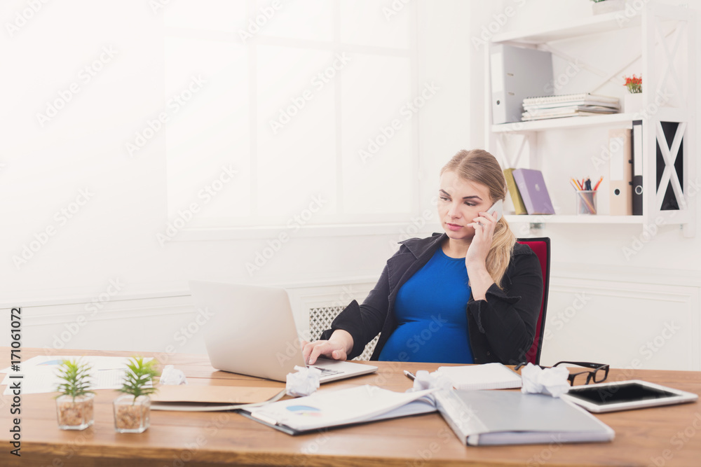 Pregnant business lady at work talking on phone Pregnant business lady at work talking on phone
