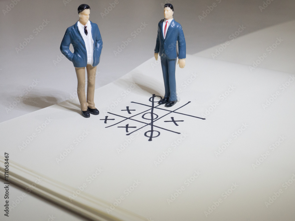 Business and direction concept. Businessman small figure standing on paper and center of circle with more arrows point to many direction.Business concept idea. Business and direction concept. Businessman small figure standing on paper and center of circle with more arrows point to many direction.Business concept idea.