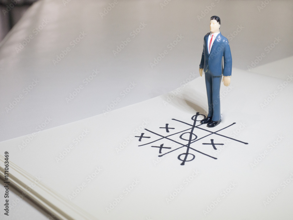 Business and direction concept. Businessman small figure standing on paper and center of circle with more arrows point to many direction.Business concept idea. Business and direction concept. Businessman small figure standing on paper and center of circle with more arrows point to many direction.Business concept idea.