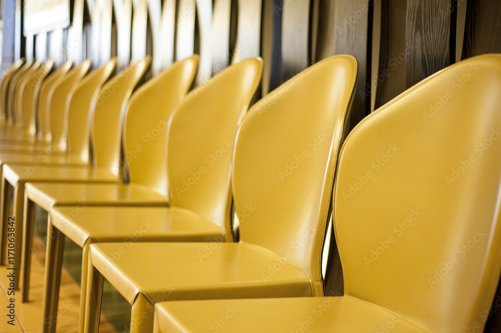 Naklejka premium Yellow chairs in a row.