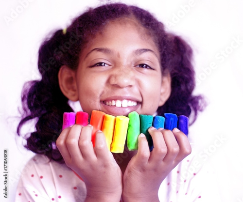 Little girl plays with colorful modeling clay