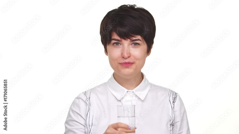 calm pretty woman with short haircut drinking water from glass isolated over white background in slowmotion calm pretty woman with short haircut drinking water from glass isolated over white background in slowmotion