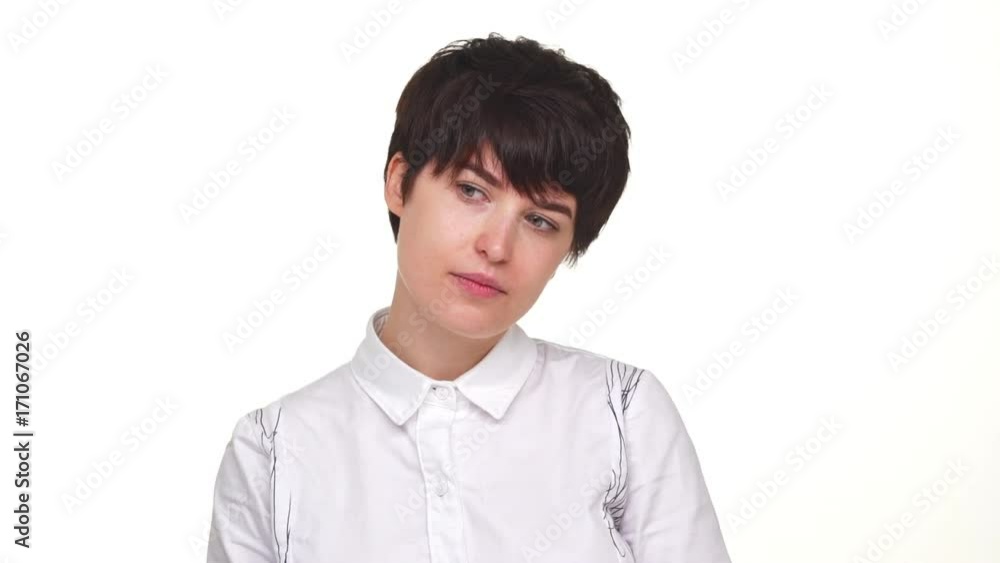 thoughtful young woman calmly looking around smiling at camera isolated over white background in slowmotion. Concept of emotions thoughtful young woman calmly looking around smiling at camera isolated over white background in slowmotion. Concept of emotions