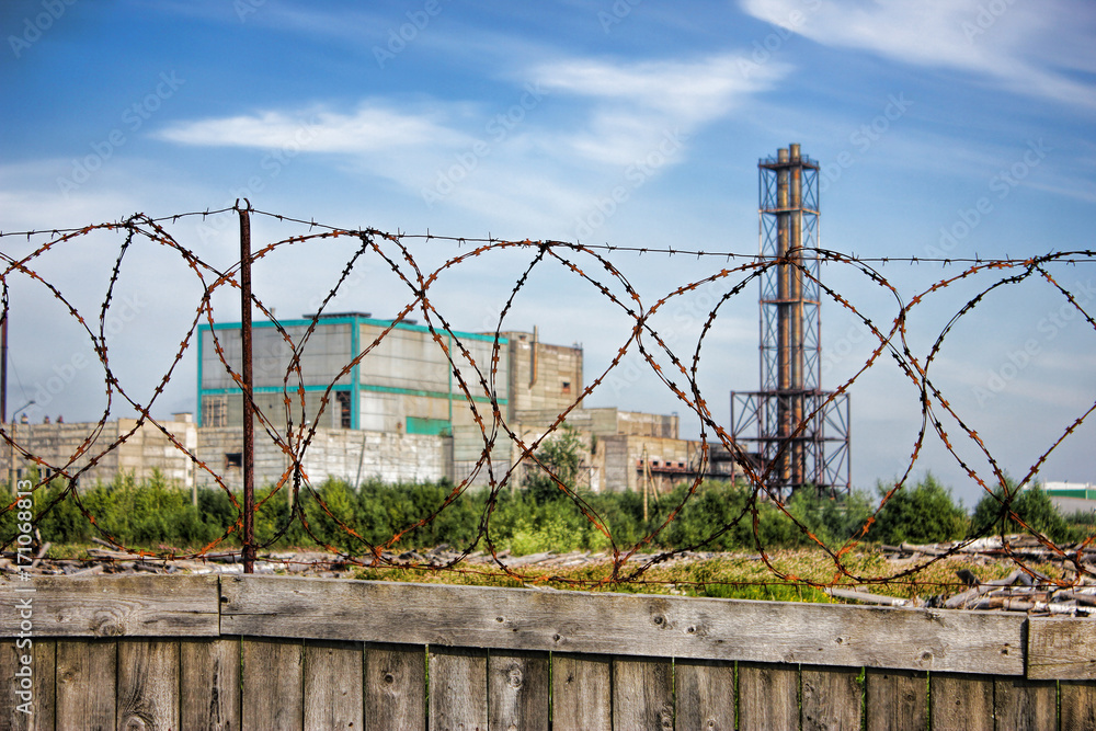 Restricted area wooden fence with barbed wire plant in the