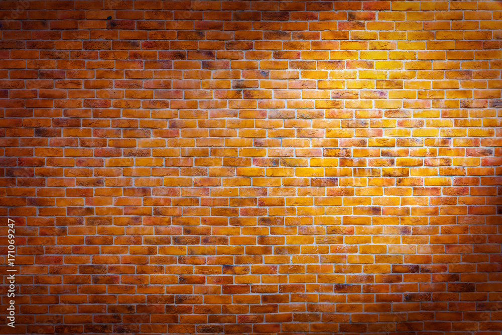 Vintage brick wall background with right spotlight on the wall Stock