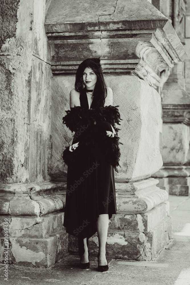 Gothic lady in a luxurious glamorous retro look for Halloween. Beautiful citizen in vintage clothing with feathers and fine accessories of handmade work. Ideas for the Halloween holiday Gothic lady in a luxurious glamorous retro look for Halloween. Beautiful citizen in vintage clothing with feathers and fine accessories of handmade work. Ideas for the Halloween holiday