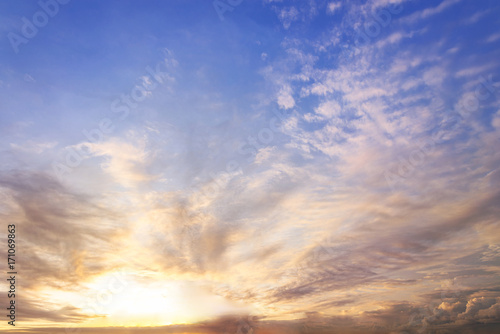 sunset / sun rise sky with rays of yellow and red light shining clouds and sky background and texture