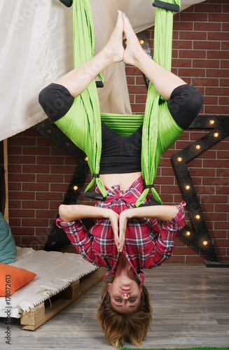 Girl hanging upside down in a hammock for yoga