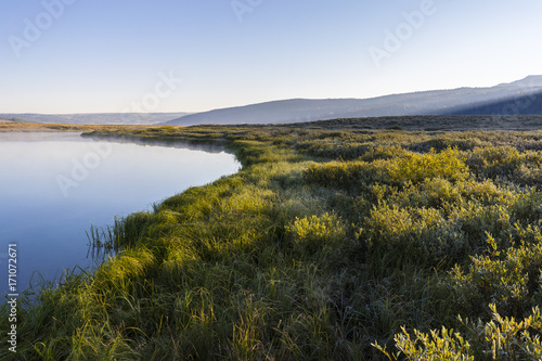 sun rising over a river valley on a cool morning 