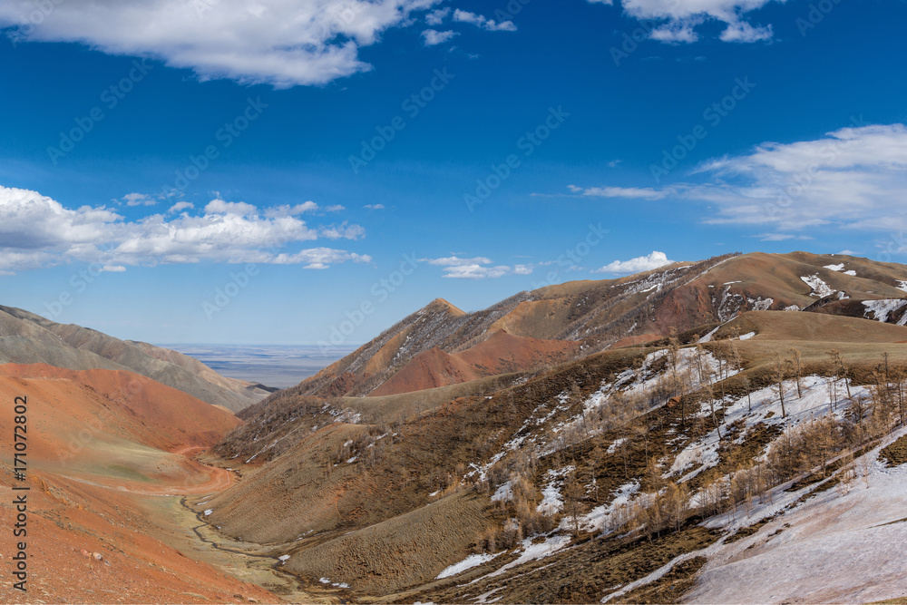 picturesque view of road between of snow-covered mountain terrain 
