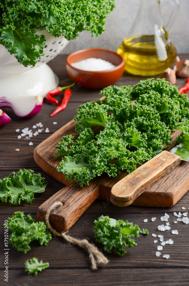 Fresh green kale with olive oil and spices, ready for cooking, selective focus Fresh green kale with olive oil and spices, ready for cooking, selective focus