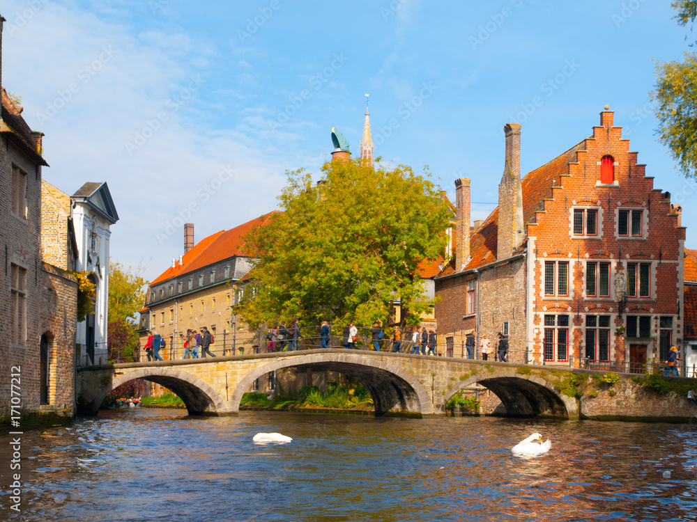 Water canal with old bridge and medieval houses at Begijnhof, Bruges, Belgium.