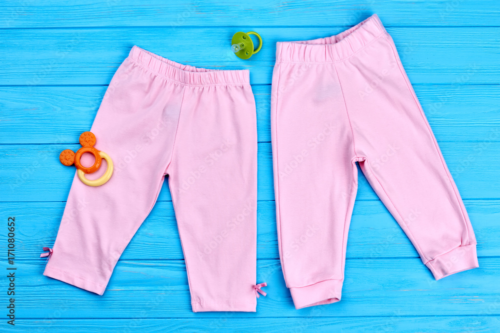 Collection of trendy stretch baby leggings. Modern colored pants for baby-girl,  pacifier. Cotton pink baby-girl summer capri, accessories. Natural kids  clothes. Stock Photo | Adobe Stock