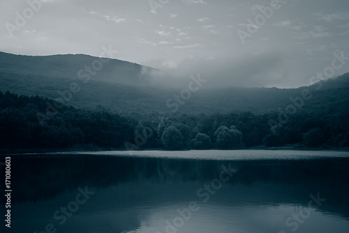Early morning on the lake in the mountains. Monochrome photo.