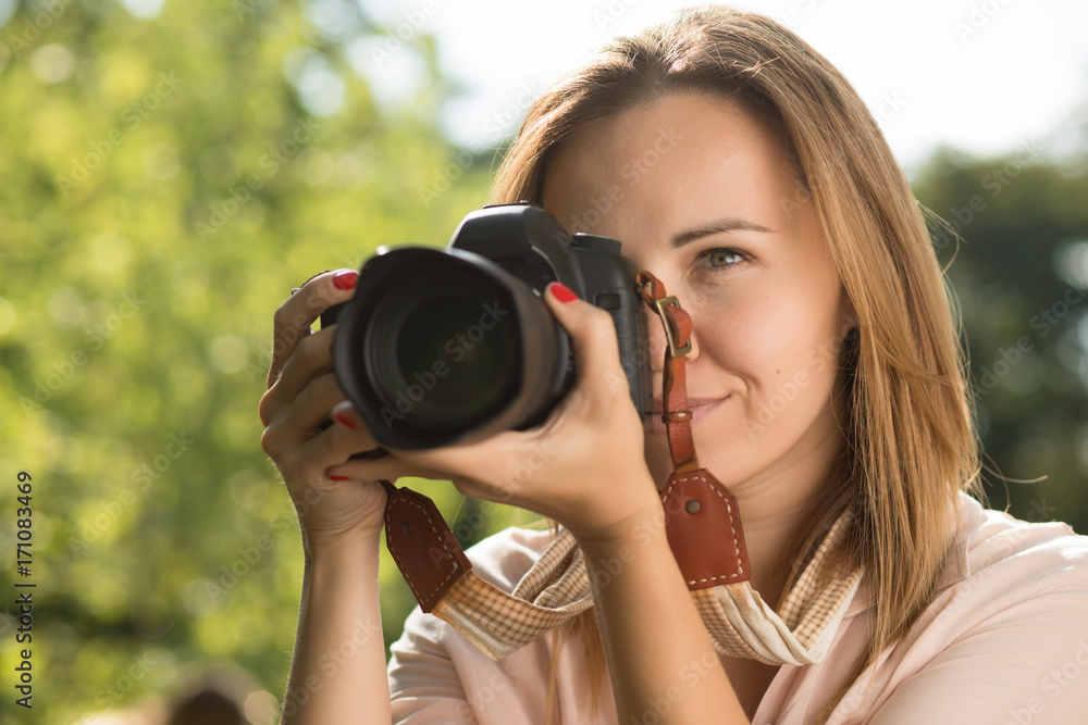 Woman photographer make shoot holding camera near her face