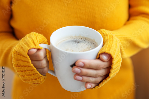Cup of delicious latte in hand. Beverage concept, lifestyle, autumn and winter.