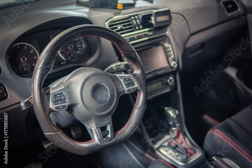Dark luxury car Interior - steering wheel, shift lever and dashboard. © vchalup