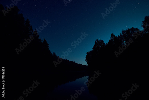 Starry sky over the night river. Russia.
