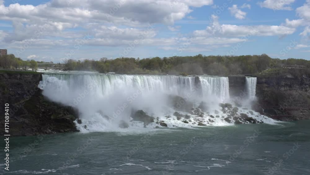 Niagara Falls in day time, with blue sky and clouds, as seen from the Canada Niagara Falls in day time, with blue sky and clouds, as seen from the Canada