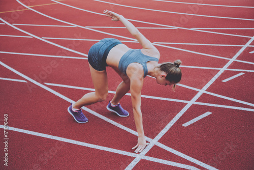 Female athlete in position ready to run. Young woman ready for a sprint.