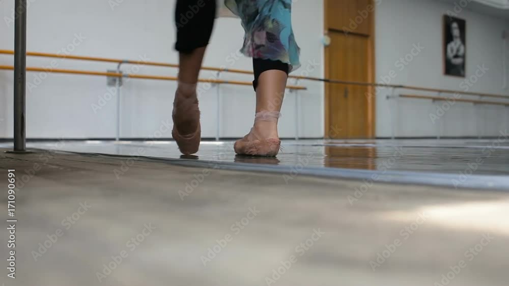 Professional ballet dancer practicing near a ballet bar. Close-up leg shoot Professional ballet dancer practicing near a ballet bar. Close-up leg shoot