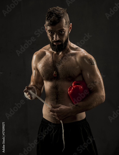 Boxer tying tape around his hand preparing to fight © serhii