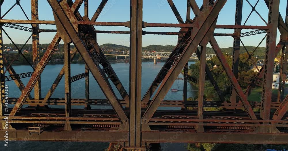 A dramatic profile aerial view of an empty, large railroad bridge spanning the Ohio River in Western Pennsylvania. The towns of Monaca and Rochester in the distance. A dramatic profile aerial view of an empty, large railroad bridge spanning the Ohio River in Western Pennsylvania. The towns of Monaca and Rochester in the distance.