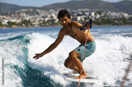 Photography Young man surfing on the wave.